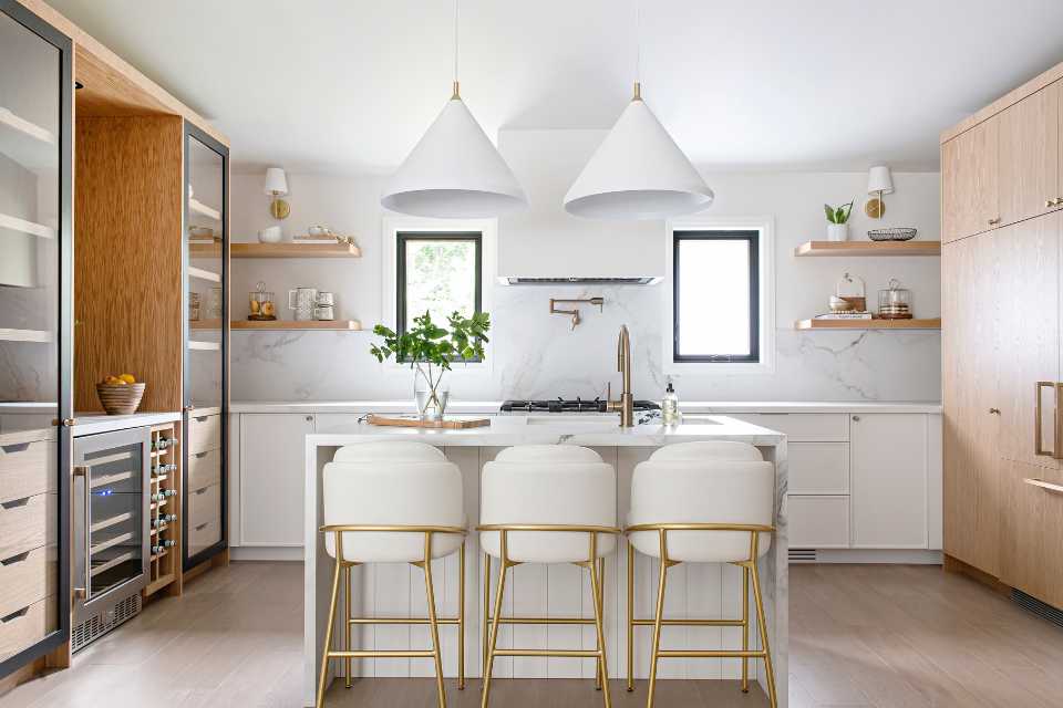 open bright and airy kitchen with marble backsplash and custom wood cabinetry